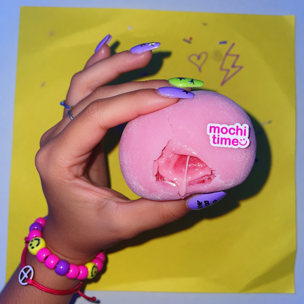 Hand holding a pink mochi snack